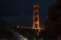 Illuminated Golden Gate Bridge at San Francisco seen through lush trees at night Royalty Free Stock Photo