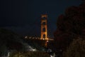 Illuminated Golden Gate Bridge at San Francisco seen through trees at night Royalty Free Stock Photo