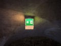 The illuminated green exit sign in dark room Royalty Free Stock Photo