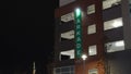 Illuminated Green Parkade Sign on Building Exterior at Night