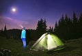 Illuminated green tent under stars at night forest , Carpathi