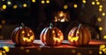 Illuminated Halloween Carved Pumpkins on wooden table. Holiday background