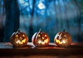 Illuminated Halloween Carved Pumpkins on wooden table. Holiday background