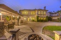 Illuminated house with a patio accomodating an outdoor dining area and fire pit Royalty Free Stock Photo