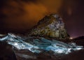 Illuminated hummocks of ice in front of a rock shaman