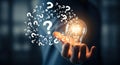 Illuminated idea bulb surrounded by a swirl of question marks Royalty Free Stock Photo