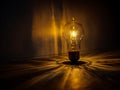 Illuminated incandescent light bulb creating warm reflections and shadows on the surface Royalty Free Stock Photo