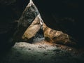 Illuminated large cave, with darkness surrounding its edges, Hengistbury Head, United Kingdom