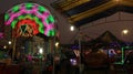 Illuminated lights of swings, long shutter of Ferris wheel Royalty Free Stock Photo