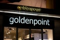 The illuminated logo of the Goldenpoint boutique which sells the fashionable apparel at night