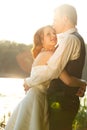 Illuminated love - wedding couple hugs behind a lake Royalty Free Stock Photo