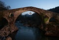 Illuminated medieval roman hump-backed stone arch bridge over Sella river in Cangas de Onis Oriente Asturias Spain Royalty Free Stock Photo