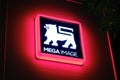 Illuminated Mega Image logo sign at night. Mega Image is a supermarket chain, established in Romania in 1995