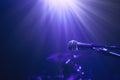 Illuminated microphone against drum kit on stage Royalty Free Stock Photo