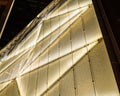 Illuminated modern building facade made of geometric glass. Royalty Free Stock Photo