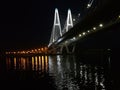 Illuminated modern cable-stayed bridge over the river in the night city Royalty Free Stock Photo