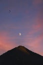 Illuminated mountain peak with moon and paraglider above Royalty Free Stock Photo