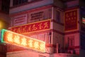 Illuminated neon light sign hanging on a building in Kowloon City, Hong Kong at night