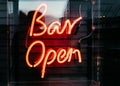 Illuminated neon orange [Bar Open] sign on a black striped background Royalty Free Stock Photo