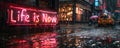 Illuminated neon sign in a rainy cityscape boldly declaring Life is Now, emphasizing the concept of living in the moment and Royalty Free Stock Photo