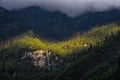 Illuminated Nepali mountain forests, near Tatopani, with green slopes on a cloudy and foggy Royalty Free Stock Photo