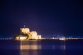 Illuminated old town of Nafplion in Greece with tiled roofs, small port, bourtzi castle, Palamidi fortress. Royalty Free Stock Photo