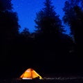 Illuminated orange tent at night in the forest Royalty Free Stock Photo