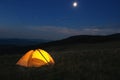 Illuminated orange tent at top of mountain at night Royalty Free Stock Photo