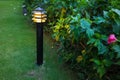 Illuminated outdoor light in apartment garden at twilight, evening.