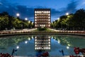 Illuminated Palazzo della Civilta Italiana and its reflection in the pond in Rome, Italy