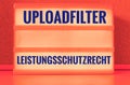 Illuminated panel with the german words Uploadfilter Artikel 13 Leistungsschutzrecht in english Upload filter Article 13 ancillary