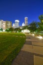 Illuminated pathway concrete sidewalk at park square with downtown Houston skyscraper, capitol tower in background during evening Royalty Free Stock Photo