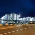 Illuminated petrochemical production plant against a blue sky at twilight, Antwerp