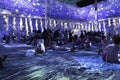 Illuminated purple room with people sitting and lying down enjoying their experience