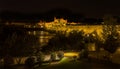 The illuminated Roman bridge and old town of Cordoba, Spain viewed from the river bank at night
