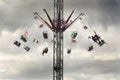Illuminated, rotating swing ride up a tower at a funfair. 1