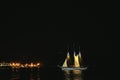 Illuminated sailboat entering port at night Royalty Free Stock Photo