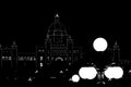 Illuminated silhouette of British Columbia Parliament. Illuminated street lamps in the foreground.