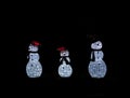 Illuminated snow family yard Christmas decorations in the dark Royalty Free Stock Photo