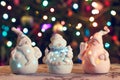 Illuminated Snowman and Jack Frost (Santa Claus) dolls in front of Christmas tree lights, blurred background Royalty Free Stock Photo