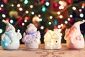 Illuminated Snowman and Jack Frost (Santa Claus) dolls in front of Christmas tree lights, blurred background Royalty Free Stock Photo