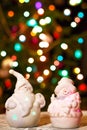 Illuminated Snowman and Jack Frost (Santa Claus) dolls in front of Christmas tree lights, blurred background Royalty Free Stock Photo