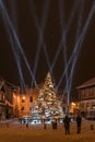 Illuminated, snowy Christmas tree with decorations and laser beams, Kuldiga, Latvia