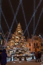 Illuminated, snowy Christmas tree with decorations and laser beams, Kuldiga, Latvia