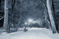 Illuminated snowy pathway in a park on a cold winter night