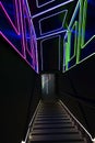 Illuminated stairway down decorated by neon lines pattern on walls and ceiling. Entrance to disco night party. Royalty Free Stock Photo
