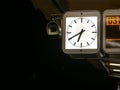 Illuminated station clock, in the evening on the platform of a subway station