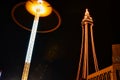 Illuminated street lamp and tower at night with a glowing halo effect and dark sky Royalty Free Stock Photo