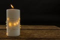 Illuminated string lights wrapped on lit candle