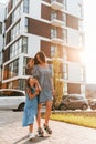 Illuminated by sunlight. Young mother with her little daughter walking near the buildings Royalty Free Stock Photo